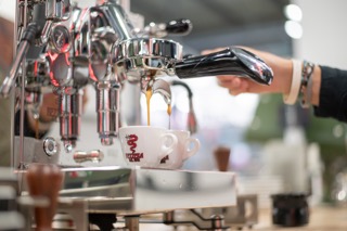 Espresso flowing into a Bezzera cup during a machine demonstration